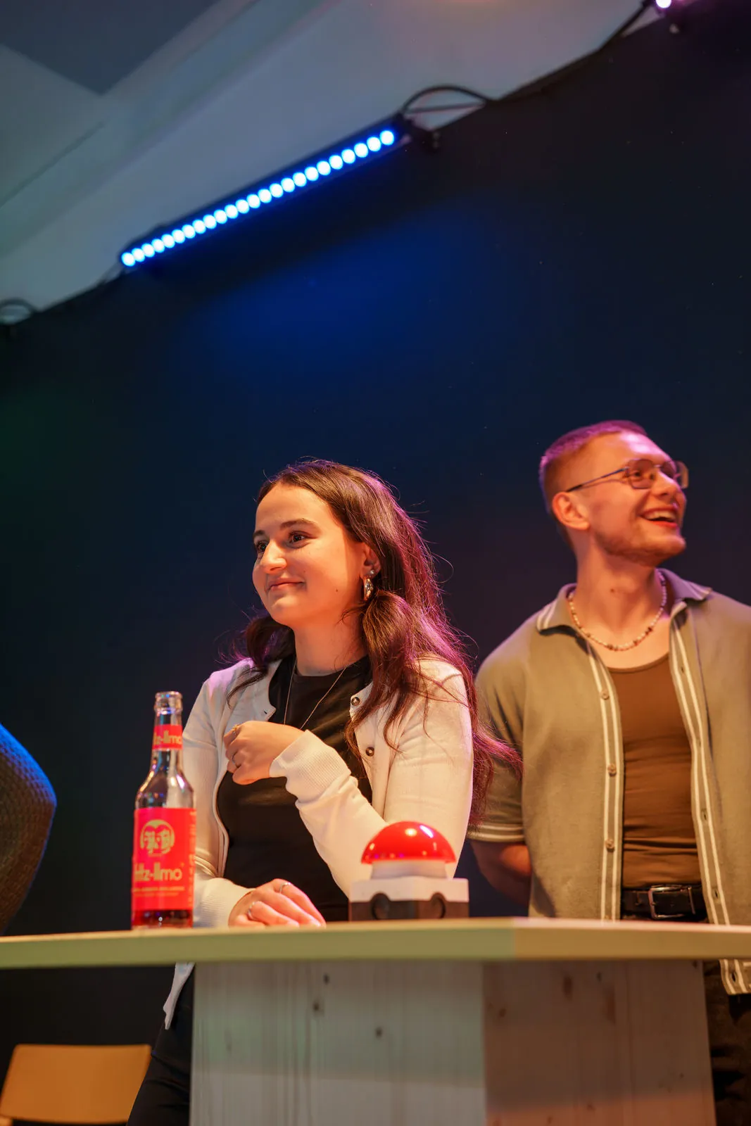 Spielerin und Spieler am Quiztisch mit Buzzer